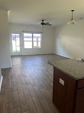Rome house for rent - an empty kitchen and living room with wood flooring