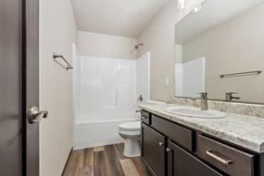 Sioux Falls apartment for rent - A bathroom with a toilet, sink, and mirror.