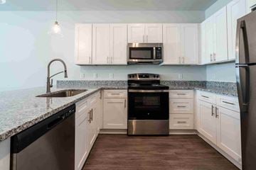 Montgomery apartment for rent - A kitchen with white cabinets and a black dishwasher.