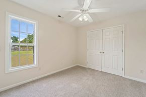 Jacksonville house for rent - a bedroom with a white door and a ceiling fan