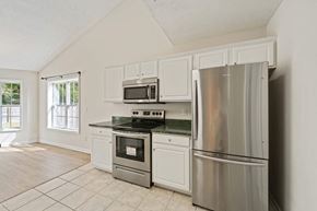 Jacksonville house for rent - a kitchen with stainless steel appliances and white cabinets