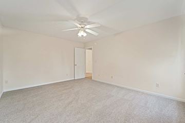 Jacksonville house for rent - a living room with carpet and a ceiling fan