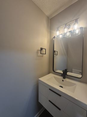 Oak Grove house for rent - A bathroom with a sink, mirror, and light fixture.