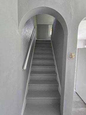 Cincinnati house for rent - a staircase in a house with an archway leading up the stairs