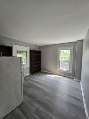 Cincinnati house for rent - an empty living room with a refrigerator and a window