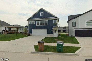 Grimes house for rent - a blue house with a driveway and two trash cans