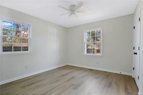 Fayetteville house for rent - an empty bedroom with a ceiling fan and two windows