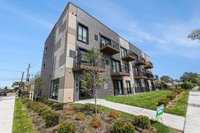 Detroit apartment for rent - A modern apartment building with balconies and a green lawn in front.