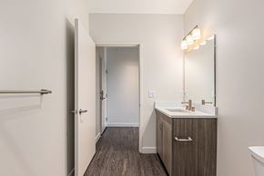 Detroit apartment for rent - A bathroom with a sink, mirror, and wooden floors.