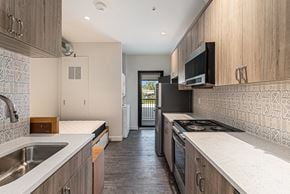 Detroit apartment for rent - A kitchen with a black stove top oven and a black microwave.