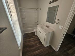 Lima apartment for rent - A white bathroom with wood floors and a white toilet.