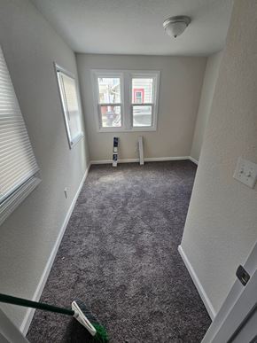 Lima apartment for rent - A room with a grey carpet and a window with blinds.