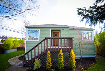 Seattle apartment for rent - A green house with a brown door and a brown staircase.