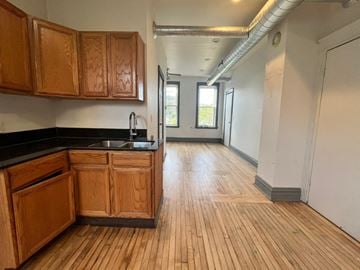 Chicago apartment for rent - A kitchen with wooden cabinets and a black countertop.