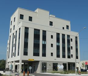 Richmond Hill apartment for rent - A large white building with a yellow caution sign on the front.