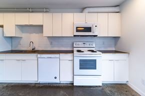 Victoria apartment for rent - A white kitchen with a stove, oven, and microwave.