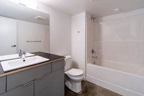 Victoria apartment for rent - A white toilet sits next to a sink in a bathroom.