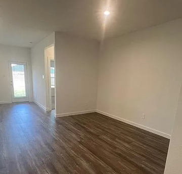 Rosharon house for rent - an empty living room with a hard wood floor