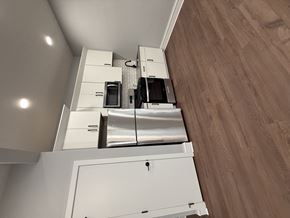Sioux City apartment for rent - A kitchen with white cabinets and a microwave above the oven.