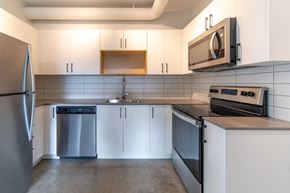Victoria apartment for rent - A modern kitchen with a refrigerator, oven, and microwave.