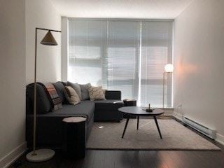 Vancouver apartment for rent - A modern living room with a grey sofa and a black floor lamp.
