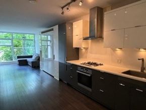 Vancouver apartment for rent - A modern kitchen with dark wood floors and white cabinets.