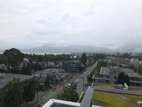 Vancouver apartment for rent - A view of a city from a high vantage point with buildings, trees, and a body of water in the distance.