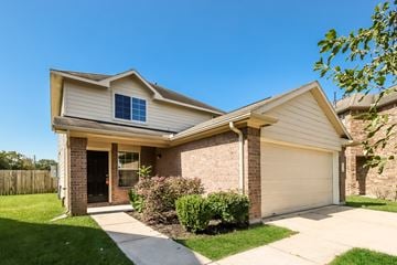 Houston apartment for rent - a tan house with a sidewalk in front of it