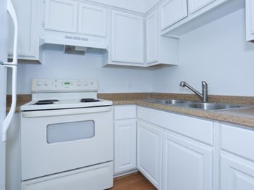 Las Vegas apartment for rent - a kitchen with white cabinets and a stove and sink