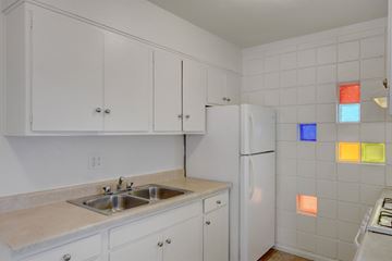 Las Vegas apartment for rent - a kitchen with white cabinets and a sink and a refrigerator