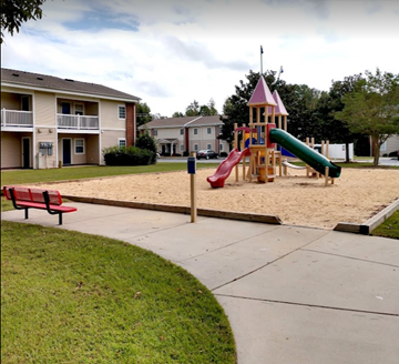Pembroke apartment for rent - a playground with a slide and sandbox in front of an apartment building
