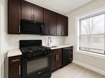 Bloomfield apartment for rent - A kitchen with dark brown cabinets and black appliances.
