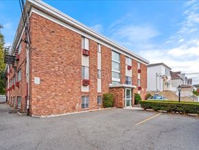 Bayonne apartment for rent - A red brick building with a white door and windows.