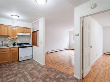 Bayonne apartment for rent - A kitchen with wooden cabinets and a tiled floor.
