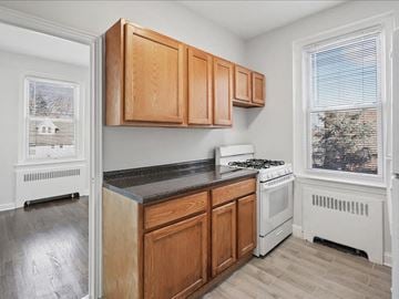 Hasbrouck Heights apartment for rent - A kitchen with wooden cabinets and a white stove.