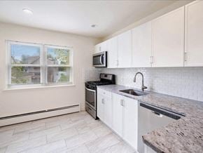 Englewood apartment for rent - A kitchen with a granite countertop and white cabinets.