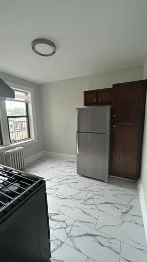 Bergenfield apartment for rent - A kitchen with a marble floor and a refrigerator.