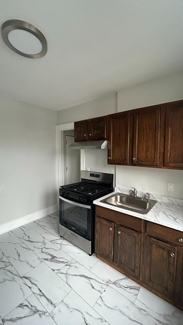 Bergenfield apartment for rent - A kitchen with a black stove top oven and a white sink.