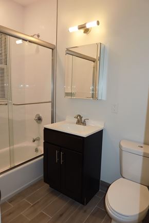 Bayonne apartment for rent - A bathroom with a toilet, sink, and mirror.
