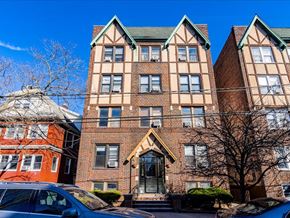 Bayonne apartment for rent - A large brick building with a green roof and a car parked in front.