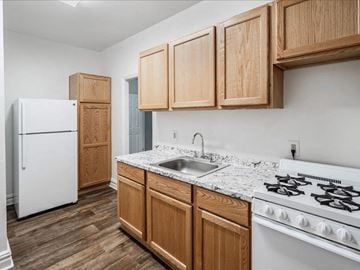 Bayonne apartment for rent - A kitchen with wooden cabinets and a white stove.