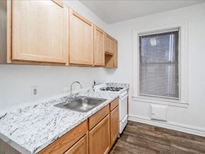 Bayonne apartment for rent - A kitchen with wooden cabinets and a marble countertop.