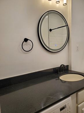 Washington apartment for rent - a bathroom with a sink and a clock on the wall
