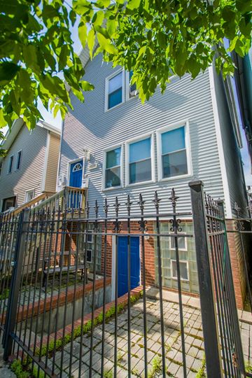 Chicago apartment for rent - an apartment building with a yard behind a wrought iron fence