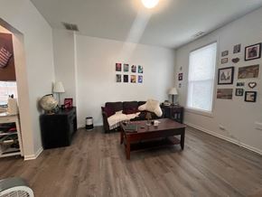Chicago apartment for rent - A living room with a couch, a coffee table, and pictures on the wall.