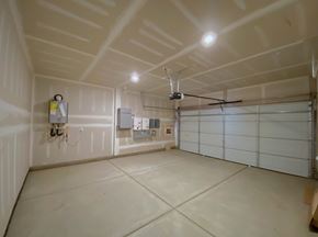 Merced house for rent - A spacious garage with a basketball hoop and a white door.