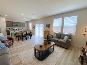 Merced house for rent - A living room with a brown leather chair and a grey couch.