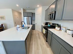 Merced house for rent - A kitchen with a white counter top and wooden floors.