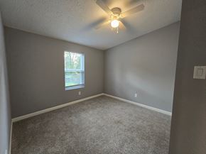 Gary house for rent - an empty bedroom with a ceiling fan and a window