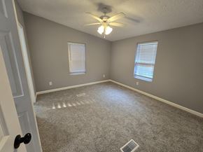 Gary house for rent - an empty living room with a ceiling fan and window